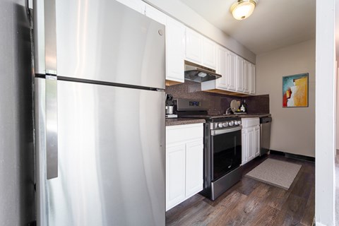 A modern kitchen with a white refrigerator and black oven.