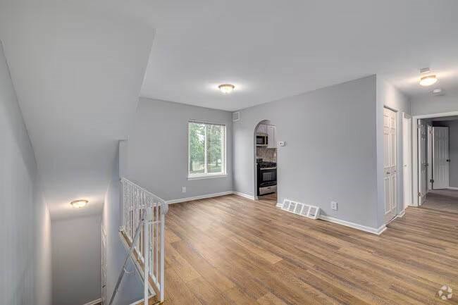 A spacious living room with wooden floors and white walls. A spacious living room with wooden floors and white walls at Brookshire Trace Townhomes Apartments, Philadelphia, PA