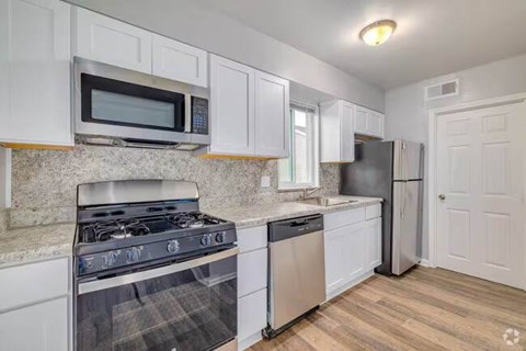 A kitchen with white cabinets and a black stove top oven.