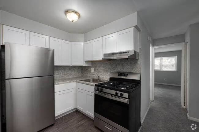 A kitchen with white cabinets and a stainless steel refrigerator.at Grant Meadows Apartments, Philadelphia, PA 19114