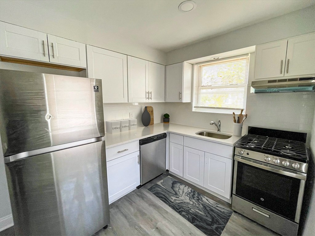 A kitchen with a stainless steel refrigerator and oven, white cabinets, and a marble floor. A kitchen with a stainless steel refrigerator and oven, white cabinets, and a marble floor.at Lawndale Apartments, Pennsylvania