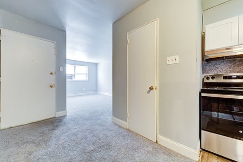 A kitchen with a stove and oven in a room with carpet.