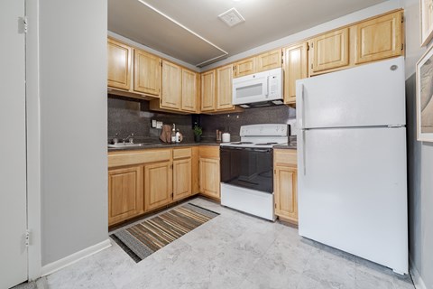 A kitchen with wooden cabinets and a white refrigerator.
