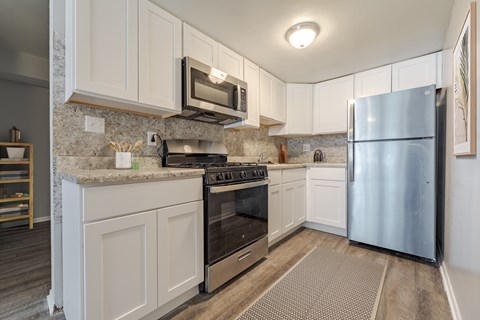 A kitchen with a stove top oven and a refrigerator.