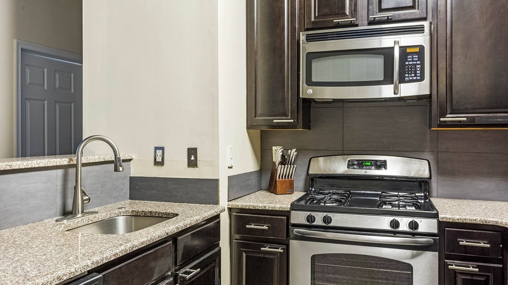A modern kitchen with a stove, sink, and microwave.at Riverview Landing @ Valley Forge, Eagleville Pennsylvania