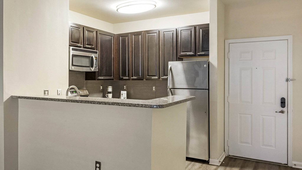 A kitchen with a white door and a stainless steel refrigerator.at Riverview Landing @ Valley Forge, Eagleville, PA