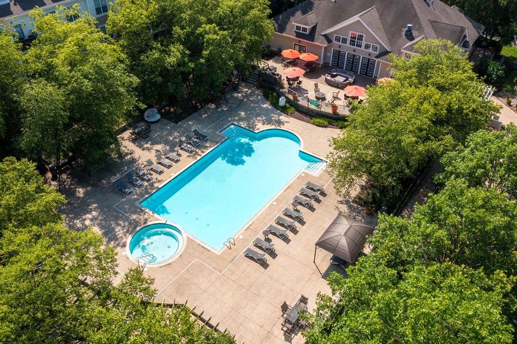 An aerial view of a pool surrounded by trees and a house.at Riverview Landing @ Valley Forge, Eagleville Pennsylvania