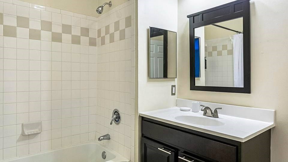 A bathroom with a white sink and a black mirror.at Riverview Landing @ Valley Forge, Eagleville Pennsylvania