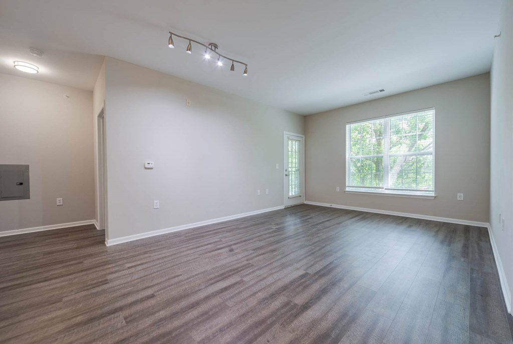 A spacious room with wooden flooring and a large window.at Riverview Landing @ Valley Forge, Pennsylvania