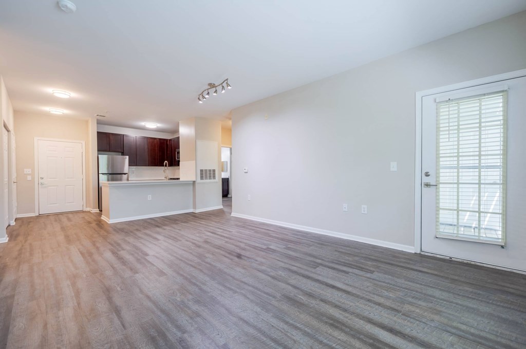 A spacious living room with a kitchen in the background.at Riverview Landing @ Valley Forge, Eagleville Pennsylvania