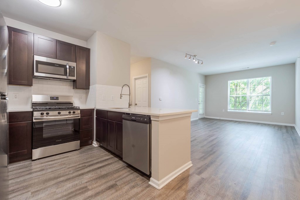 A kitchen with dark brown cabinets and stainless steel appliances.at Riverview Landing @ Valley Forge, Eagleville Pennsylvania