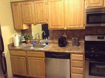 A kitchen with wooden cabinets and granite countertops. at Brookshire Trace Townhomes Apartments, Pennsylvania