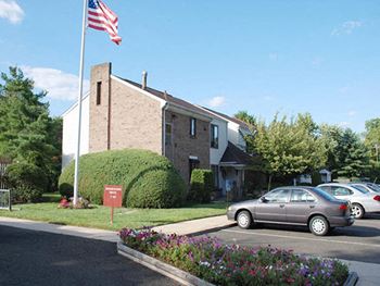 a building with an flag in front of a parking lot at Brookshire Trace Townhomes Apartments, Pennsylvania, 19116