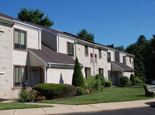 a row of white houses on the side of a street a row of white houses on the side of a street at Brookshire Trace Townhomes Apartments, Philadelphia, Pennsylvania