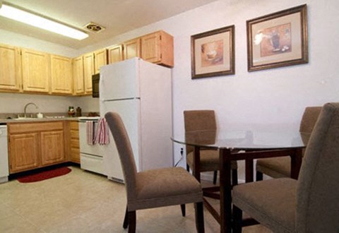 A kitchen with a table and chairs.