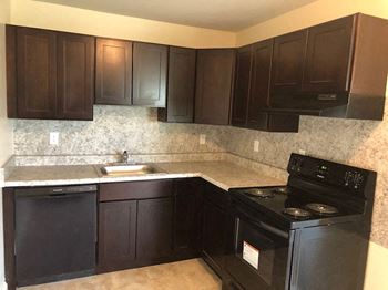 a kitchen with black appliances and black cabinets at Manchester Apartments, Philadelphia, PA