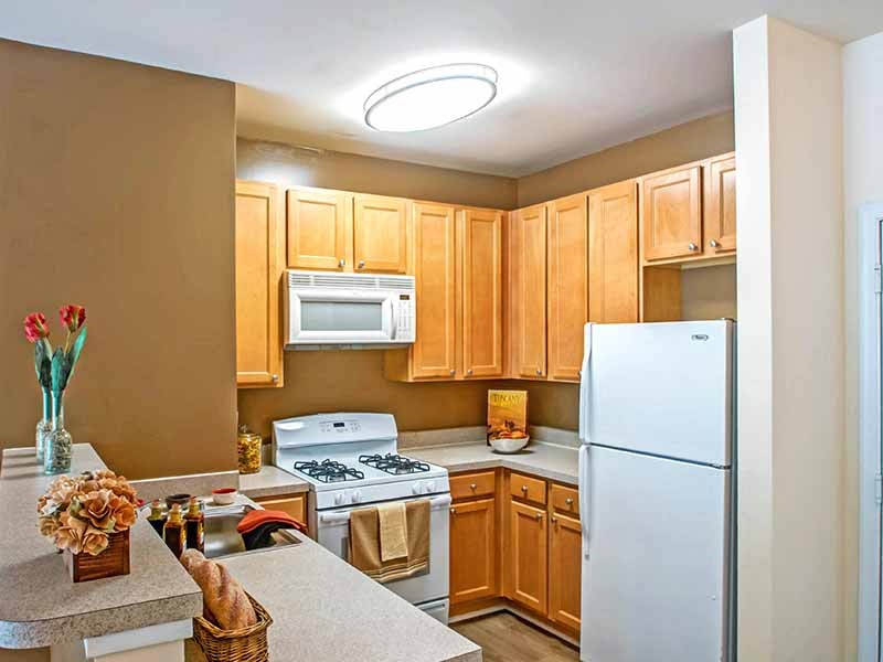 a kitchen with white appliances and wooden cabinets at Riverview Landing @ Valley Forge, Pennsylvania