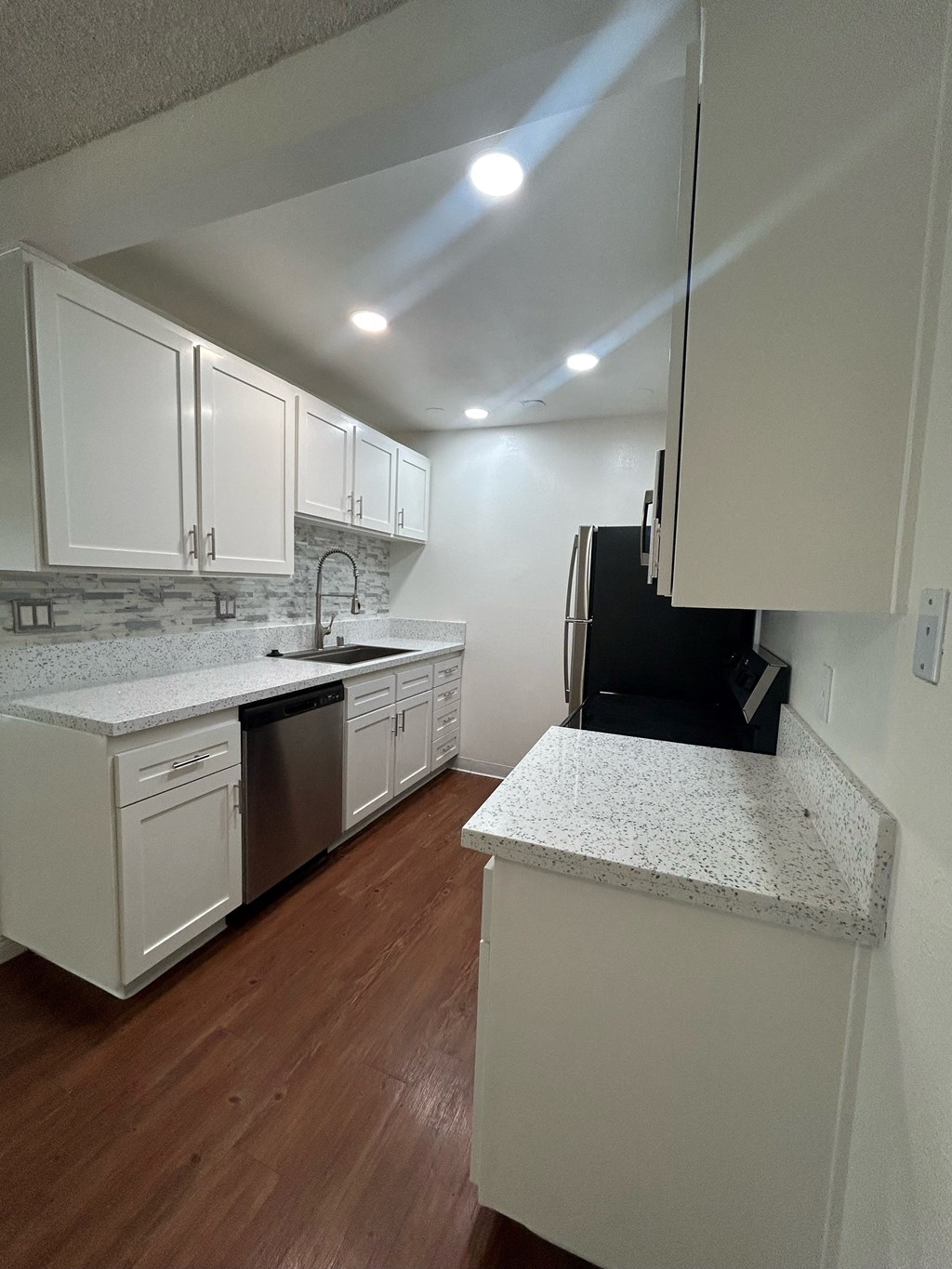 an empty kitchen with white cabinets and a counter top at Camino de Oro Apartments, Torrance, CA, 90505