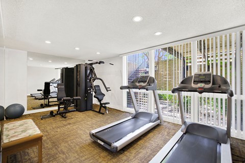 a gym with exercise equipment and a large window at Casa Del Amo Apartments, California, 90505