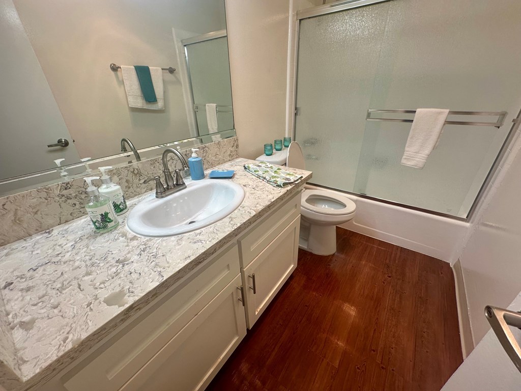 A bathroom with a marble countertop and a white sink.