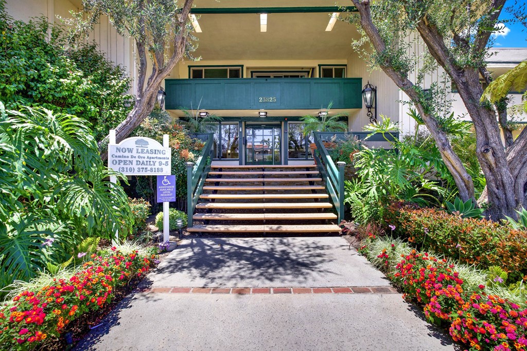 the steps up to the front of a building with plants and flowers at Camino de Oro Apartments, Torrance, CA, 90505