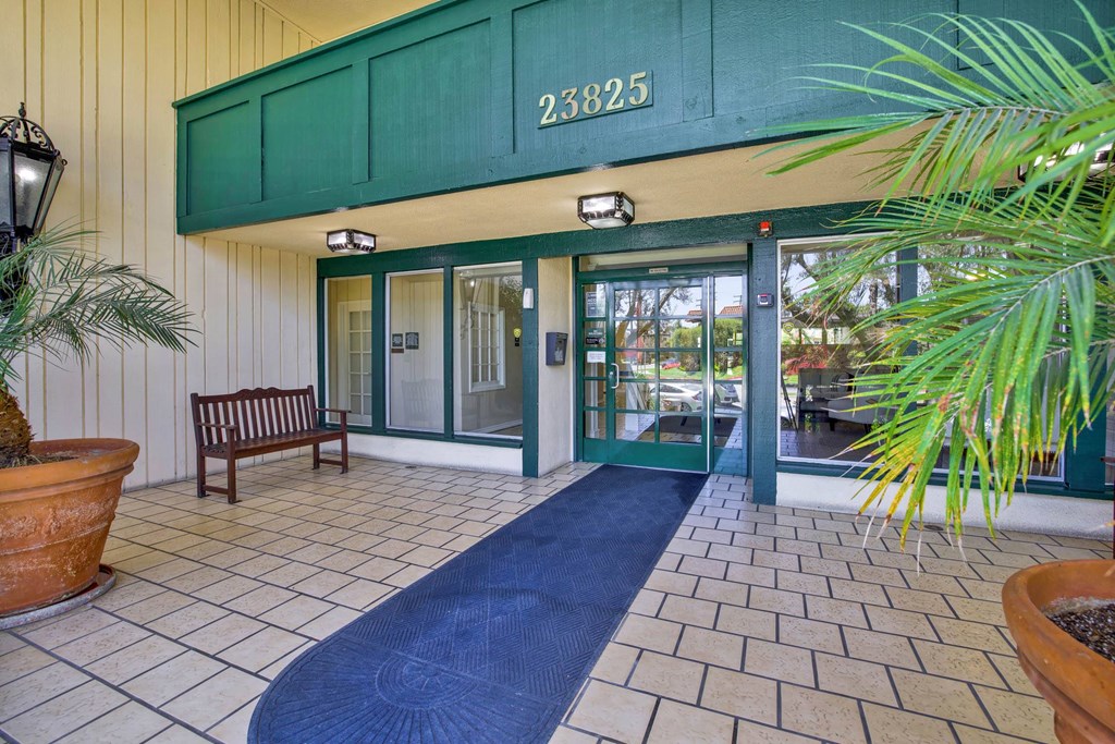 the entrance to a building with glass doors and a rug at Camino de Oro Apartments, California, 90505