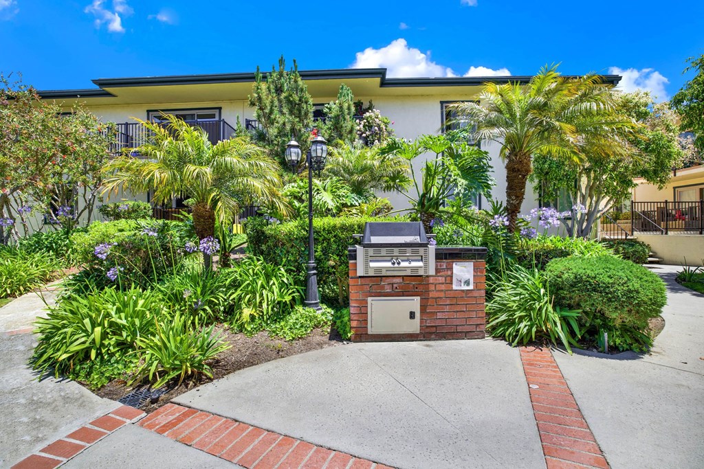 a building with a driveway and palm trees in front of it at Camino de Oro Apartments, California, 90505