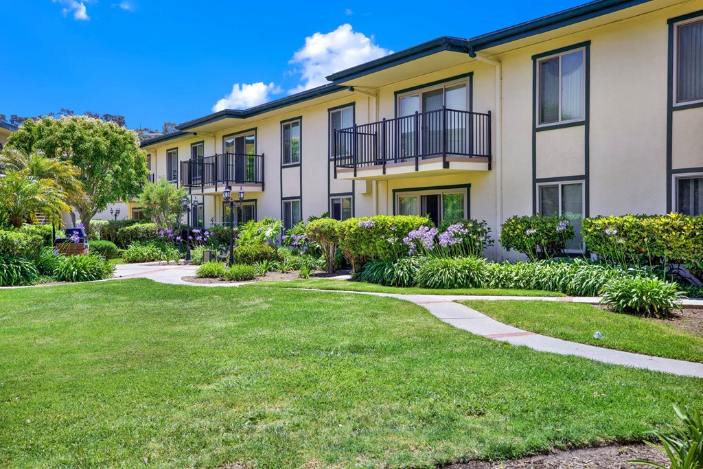 a yard in front of a building with grass and walk ways at Camino de Oro Apartments, Torrance, CA