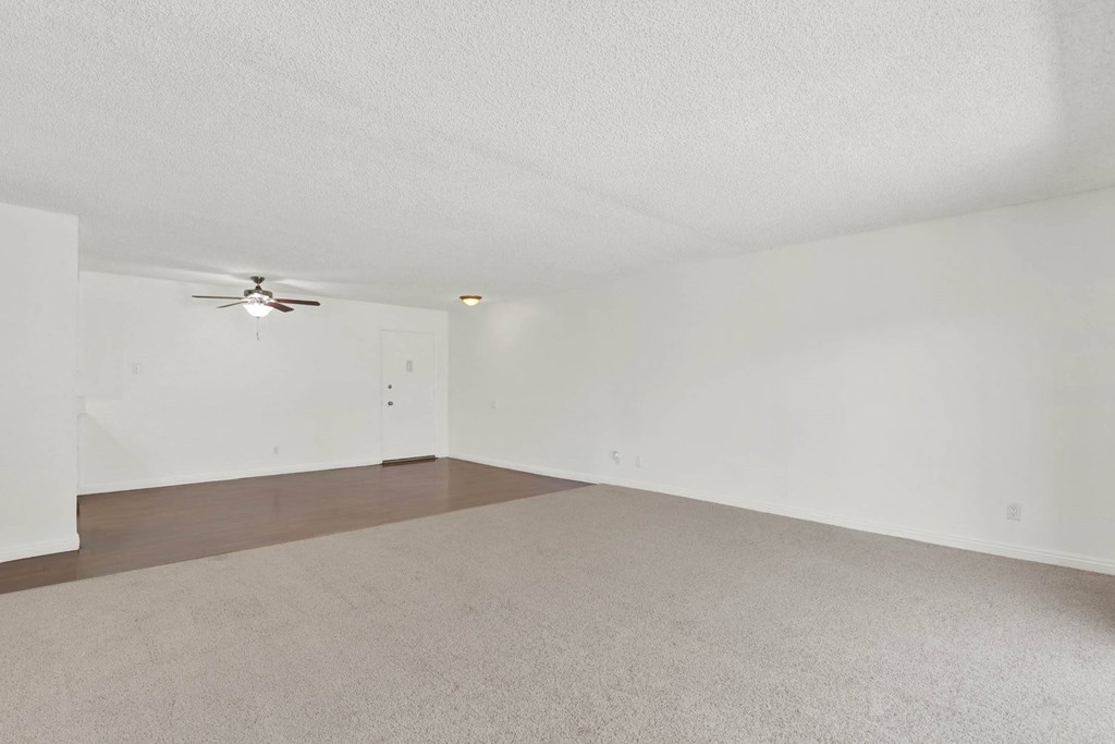 the spacious living room with white walls and a ceiling fan at Camino de Oro Apartments, Torrance, California
