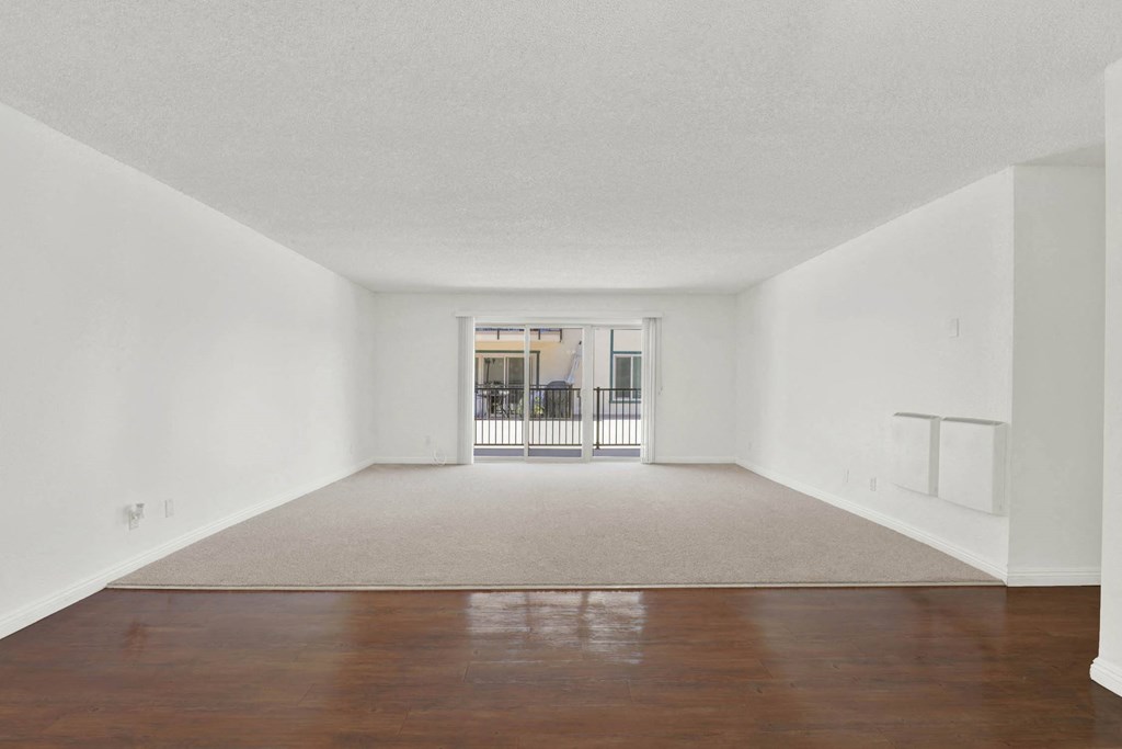 an empty living room with a hard wood floor and a balcony at Camino de Oro Apartments, Torrance, CA, 90505