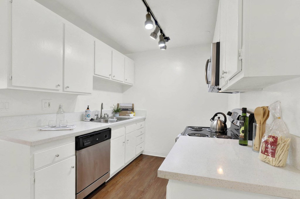 a kitchen with white counter tops and white cabinets at Camino de Oro Apartments, California, 90505