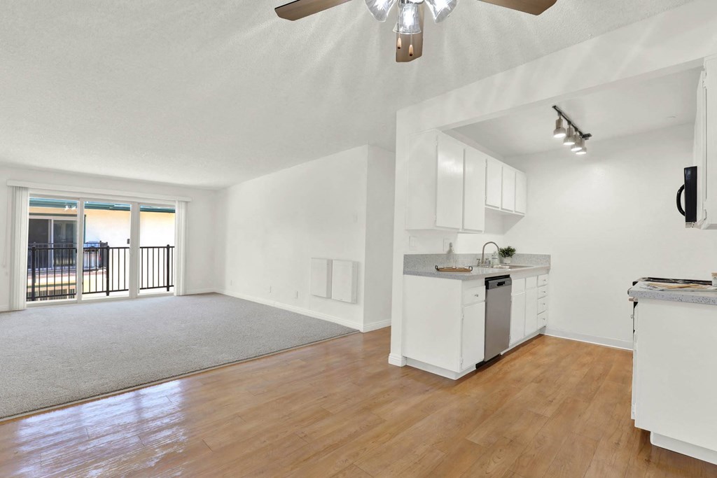 an empty living room with a kitchen and a balcony at Camino de Oro Apartments, Torrance, CA, 90505