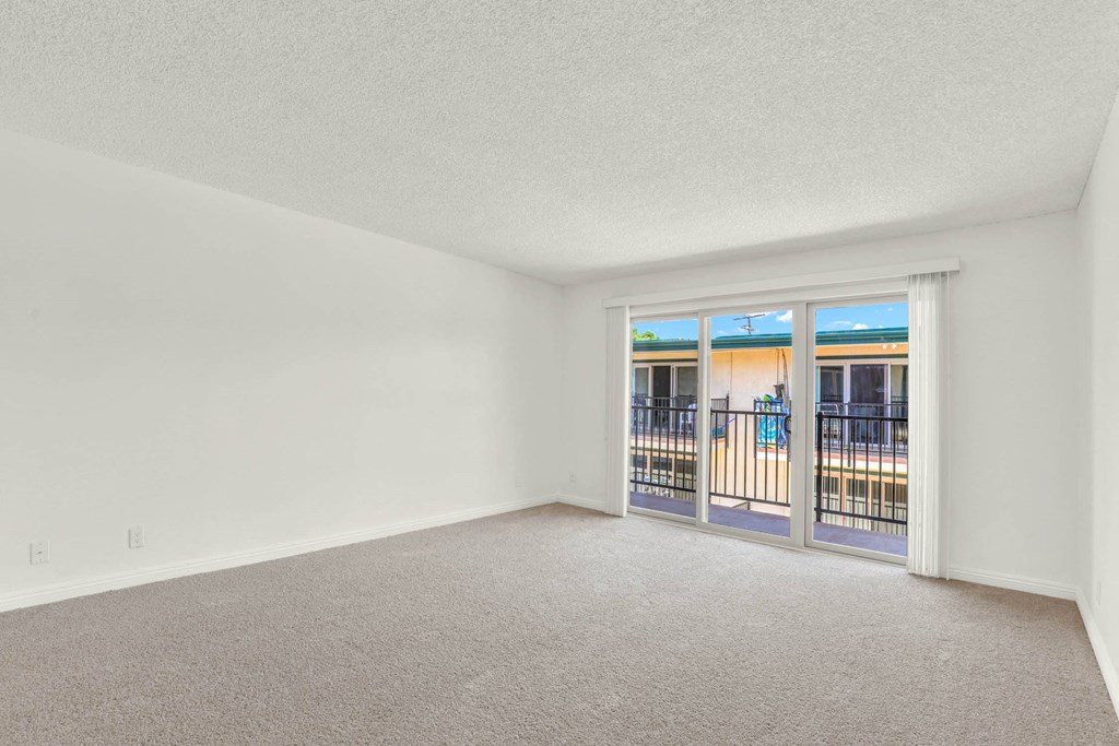 an empty living room with a door to a balcony at Camino de Oro Apartments, Torrance, CA, 90505