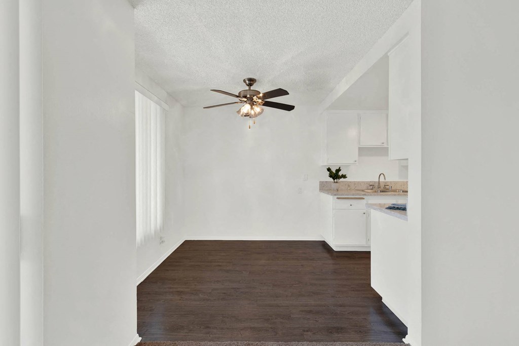 a living room with a ceiling fan and a kitchen at Casa De Oro Apartments, California, 90505