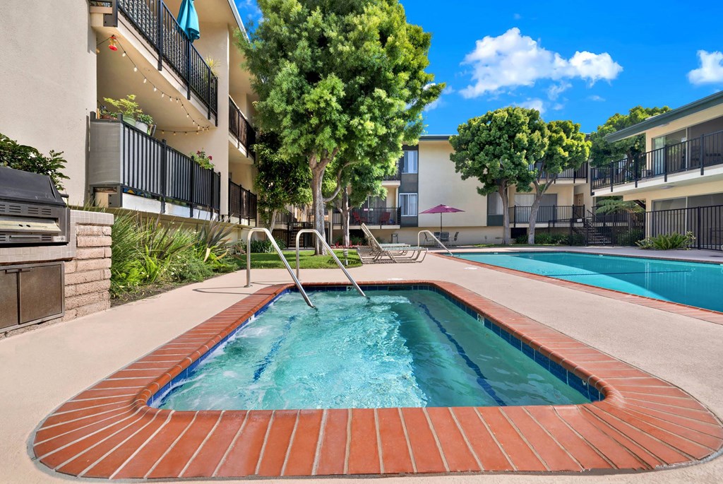 a resort style pool is next to an apartment building at Casa De Oro Apartments, Torrance, CA