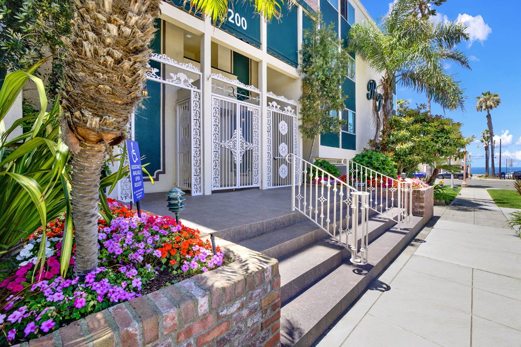 a building with palm trees and flowers in front of it  at Royal Towers Apartments, Redondo Beach, 90277