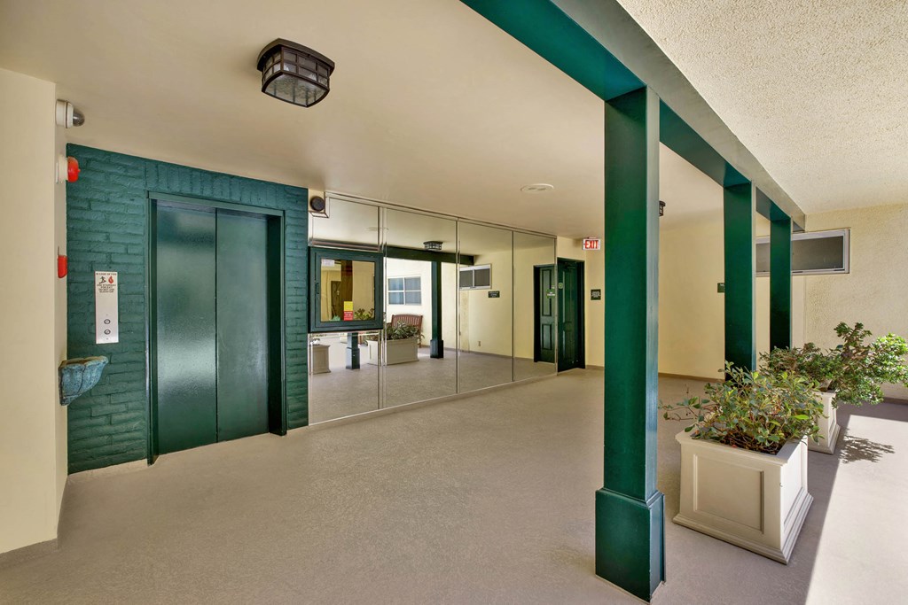 the lobby of a building with green pillars and doors  at Royal Towers Apartments, Redondo Beach, 90277