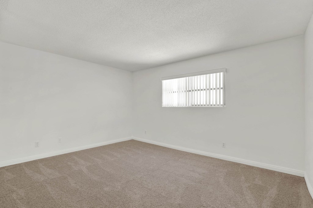 a spacious living room with white walls and a window at Royal Towers Apartments, Redondo Beach, CA, 90277