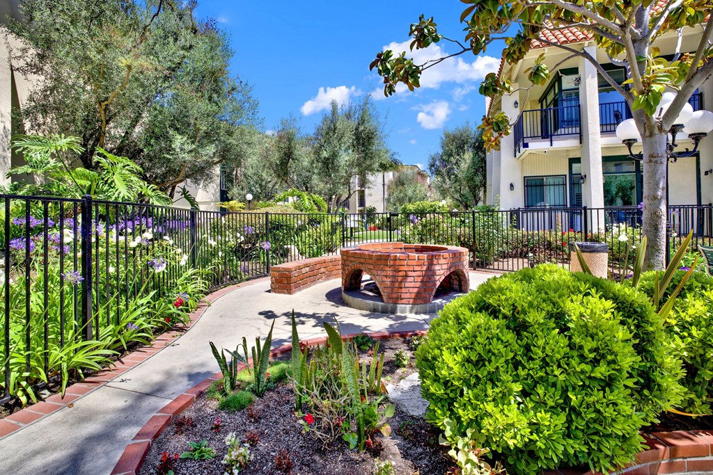 a patio with a fire pit and plants in a garden at Willow Tree Apartments, Torrance