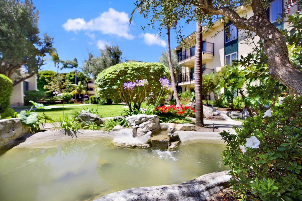 a spa with a fountain in the middle of a garden at Willow Tree Apartments, Torrance