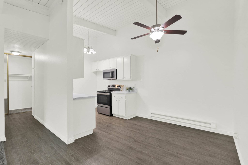 a living room with a ceiling fan and a kitchen at Willow Tree Apartments, Torrance