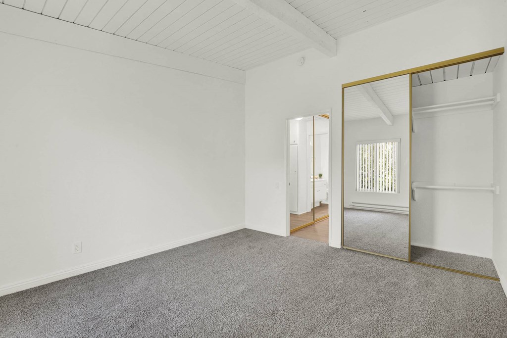 an empty room with a mirror and carpet at Willow Tree Apartments, California, 90505