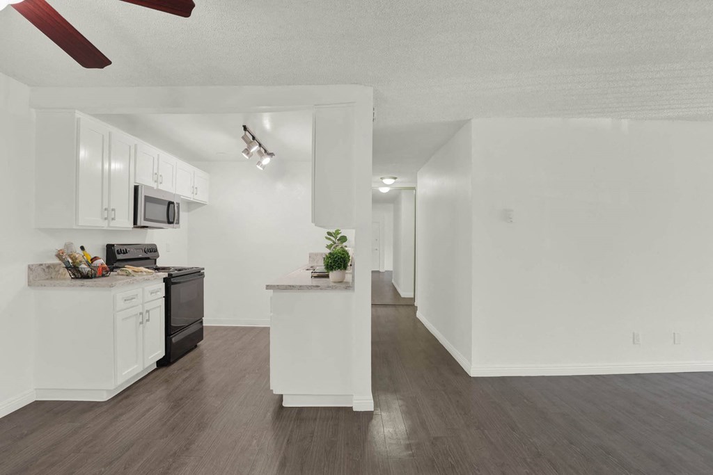 a kitchen with white cabinets and a counter top at Willow Tree Apartments, Torrance, CA