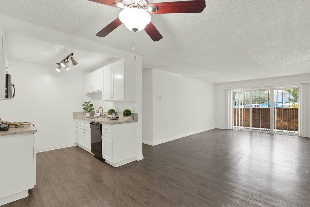 an empty living room and kitchen with a ceiling fan at Willow Tree Apartments, Torrance, CA