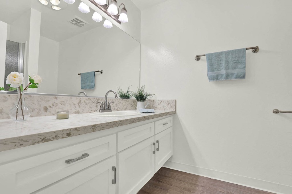 a white bathroom with a sink and a mirror at Willow Tree Apartments, Torrance, CA