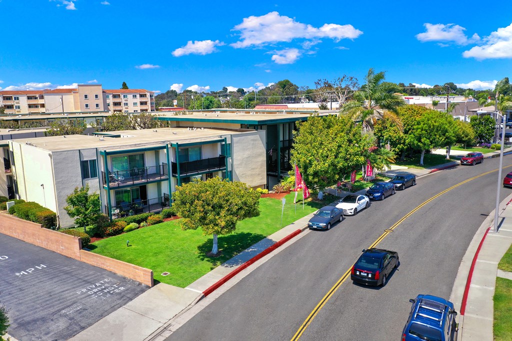 an aerial view of a building with cars parked in front of it an aerial view of a building with cars parked in front of it at Casa Del Amo Apartments, California
