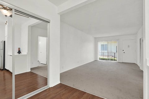 a living room with a mirror and a carpeted floor
