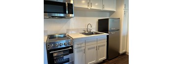 A modern kitchen with a stainless steel refrigerator, oven, and microwave.