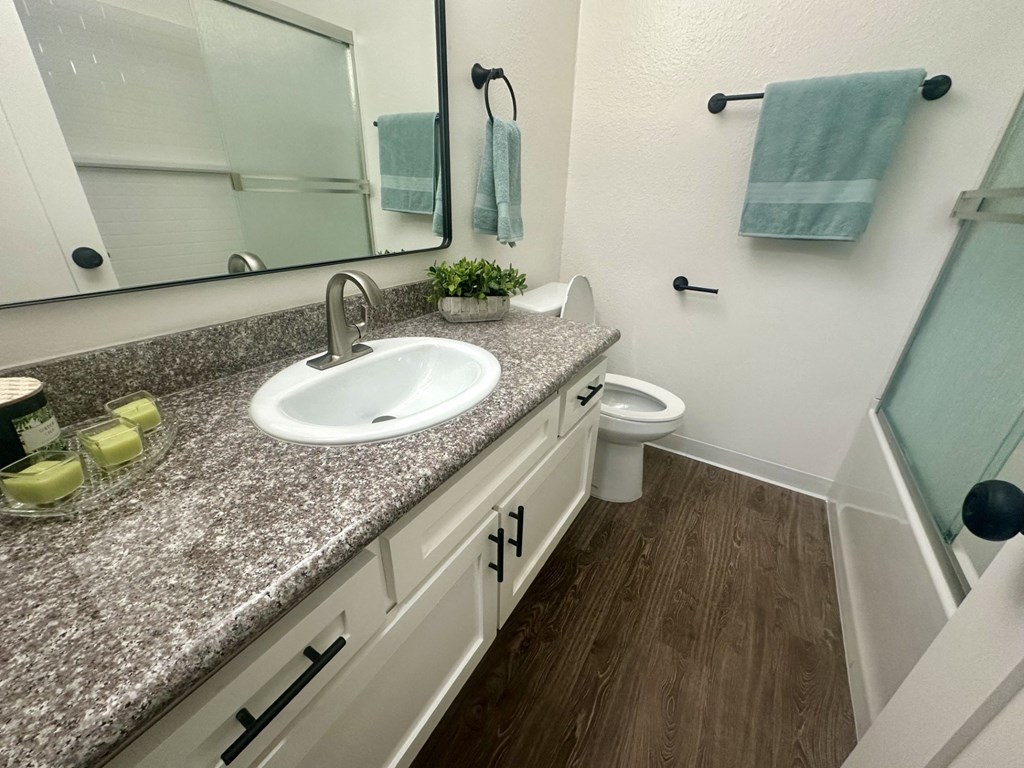 A bathroom with a granite countertop and white cabinets. at Willow Tree Apartments, California, 90505
