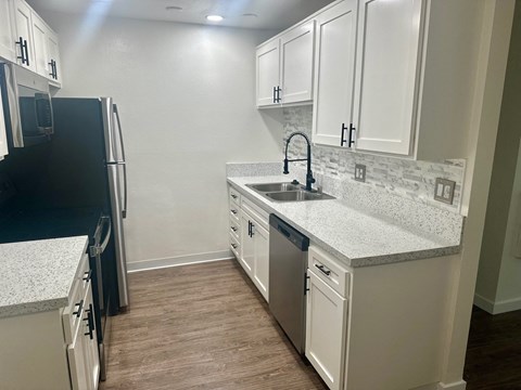 a kitchen with white cabinets and stainless steel appliances